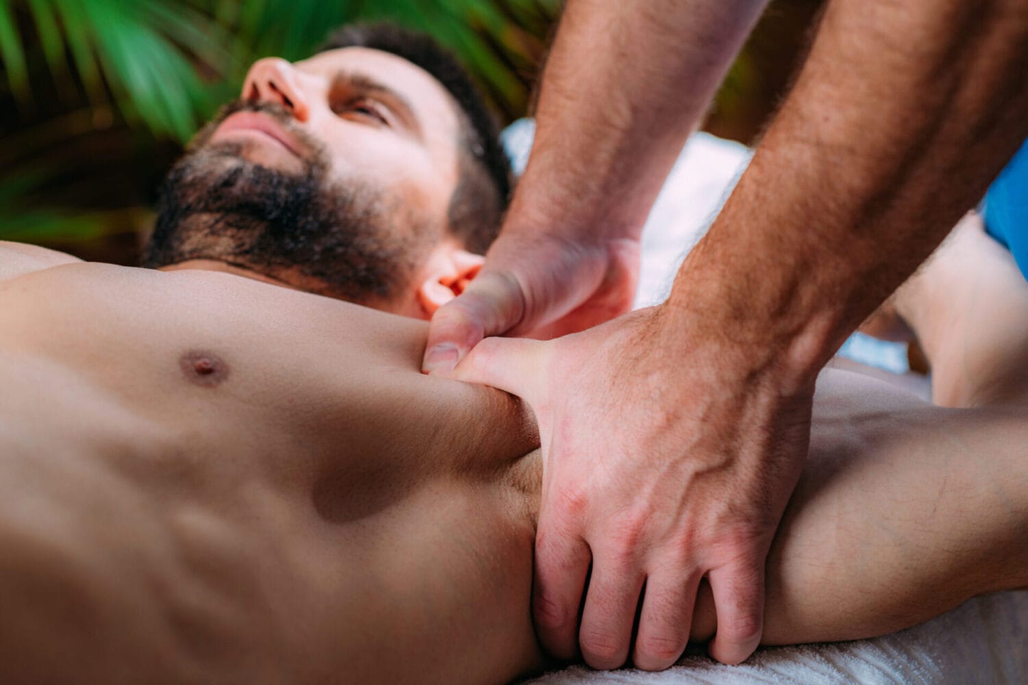 A sports massage therapist using both thumbs for a deep and restorative chest massage.