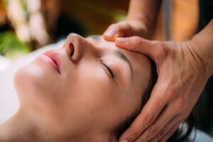 Tulsa Craniosacral Therapy being applied to a patient's head.