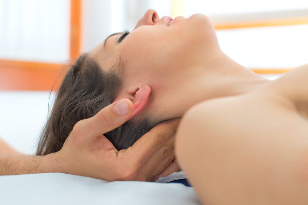 Therapist massaging the neck of woman