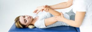 A Tulsa Massage therapist touching hand of attractive patient in grey t-shirt , preparing for active release technique therapeutic services